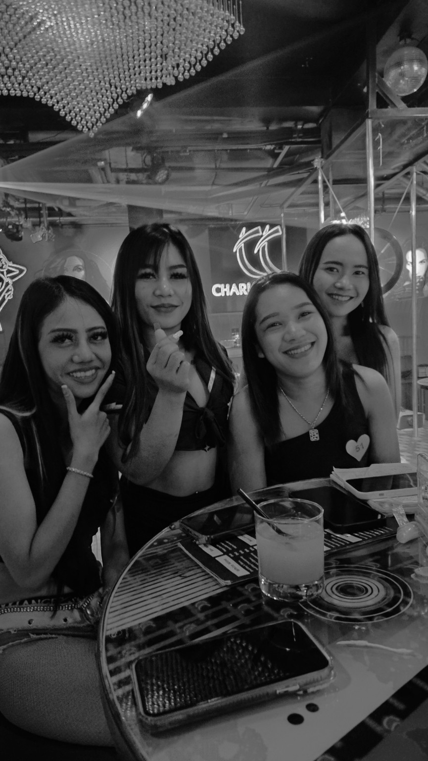 Four smiling Charlie Chan's Club team members inside the club