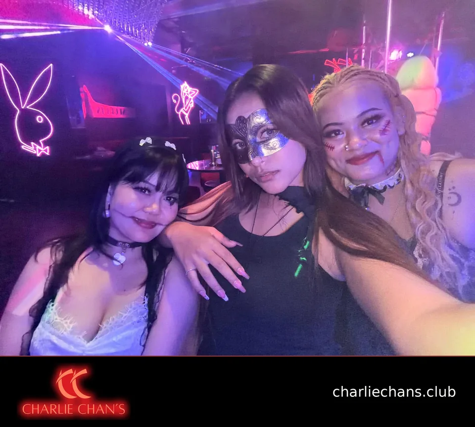 Three team members in Halloween makeup and a masquerade mask at Charlie Chan's Club