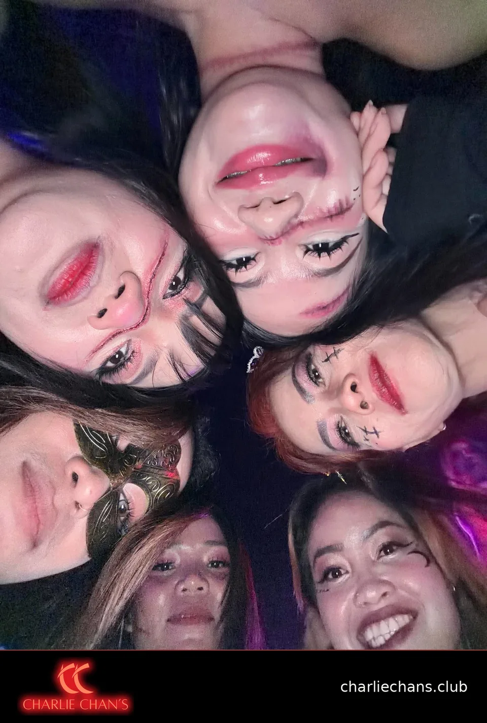 Team members forming a circle for an overhead Halloween selfie
