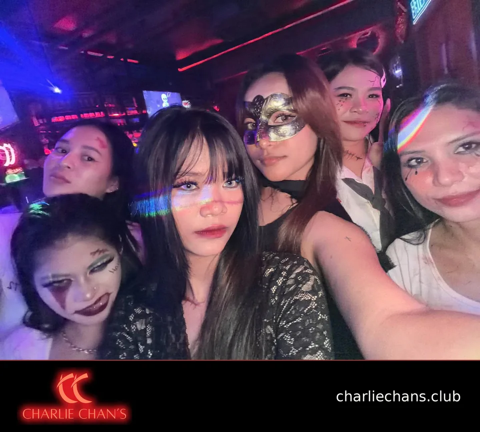 Five team members in Halloween costumes taking a group selfie